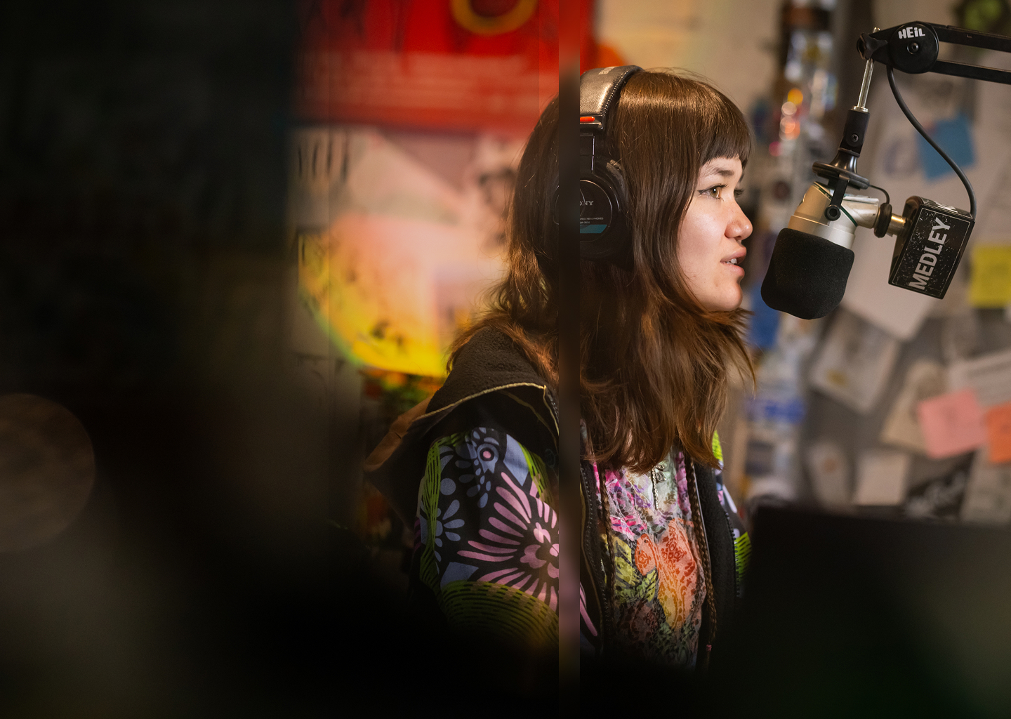 A student speaking into a microphone at a radio station